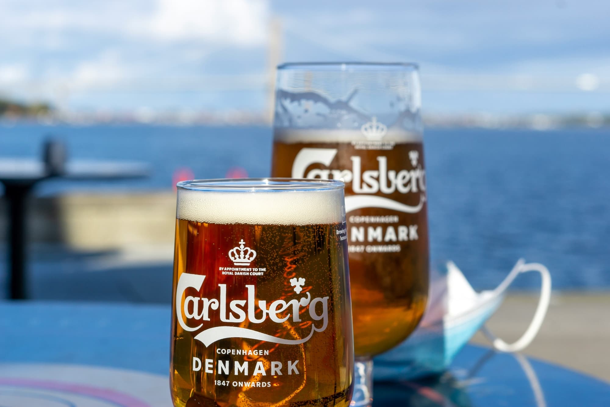 Two glasses of Danish beer on a table by the water